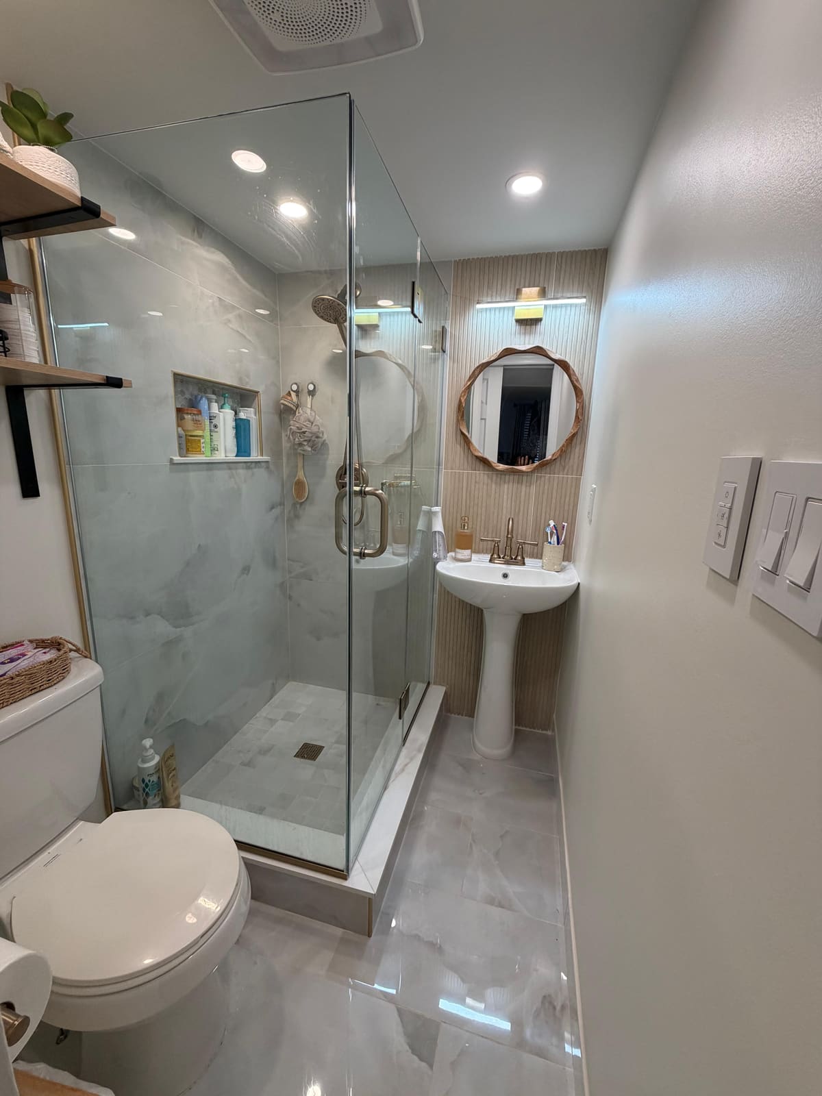 Finished bathroom remodel with glass shower enclosure, pedestal sink, and gold trim in Blackwood, NJ.