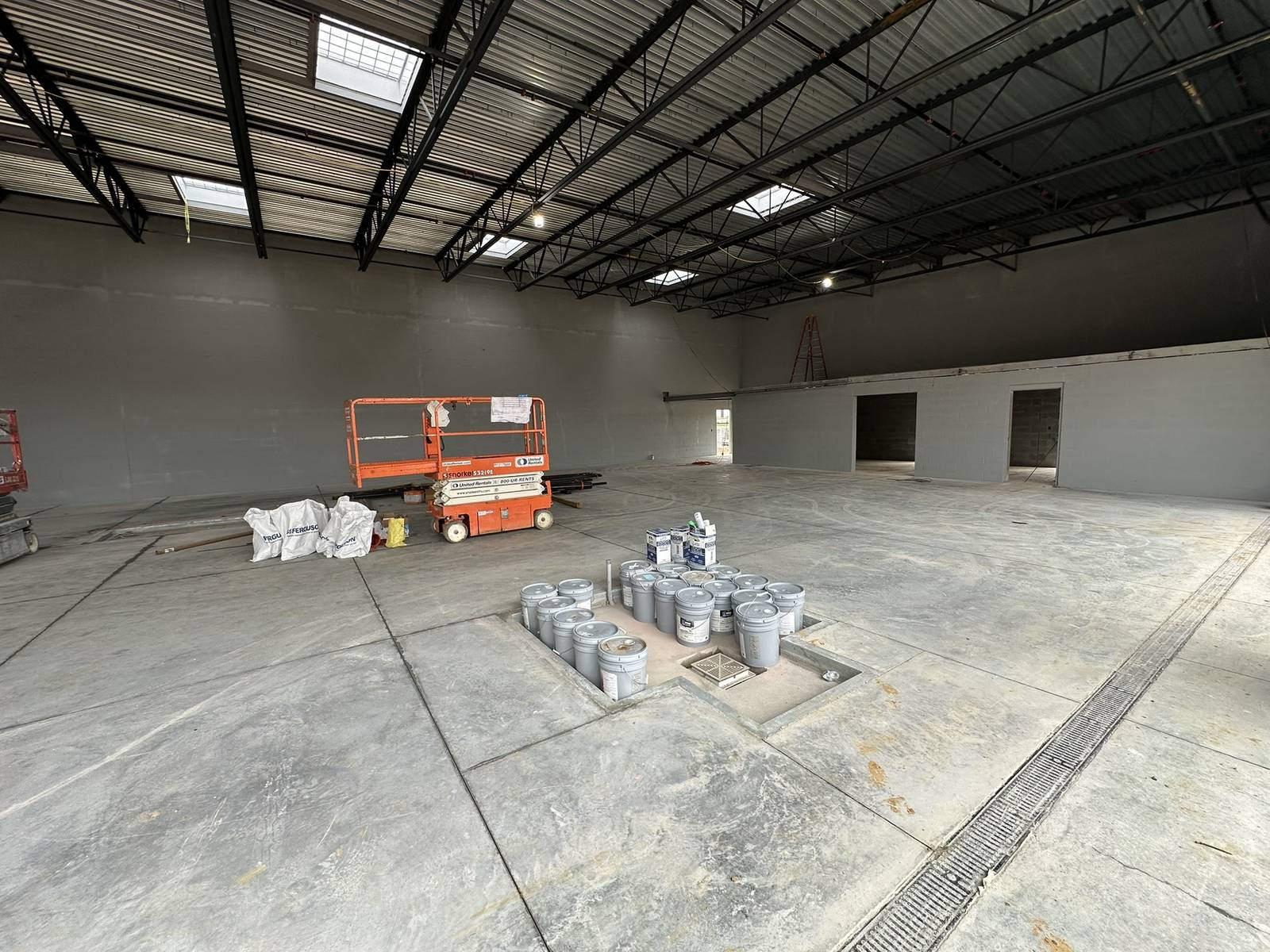 Painted concrete block walls and exposed steel roof deck after commercial painting at a tire store service bay