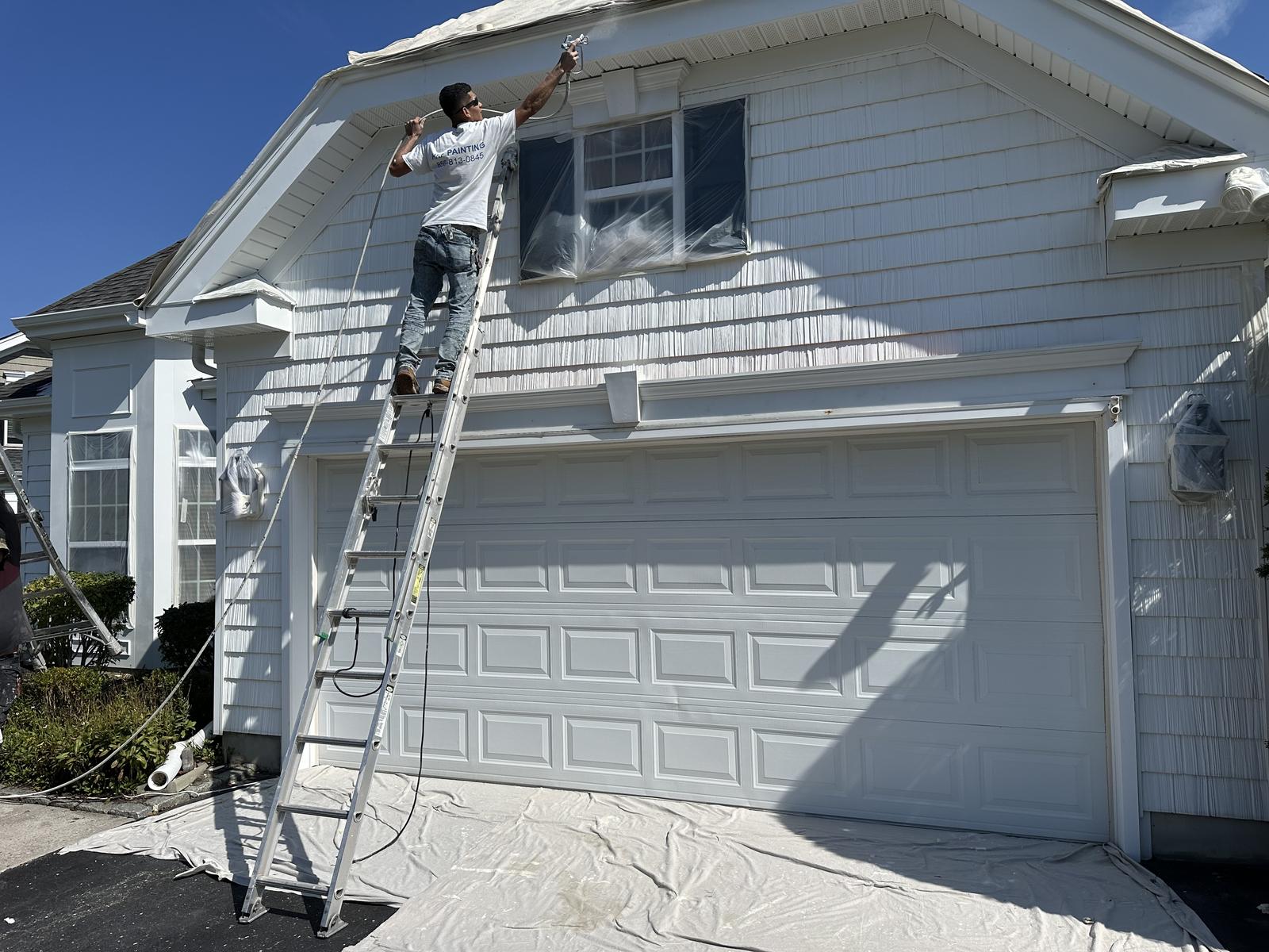 HRF Painting crew painting a house exterior from a ladder in New Jersey.
